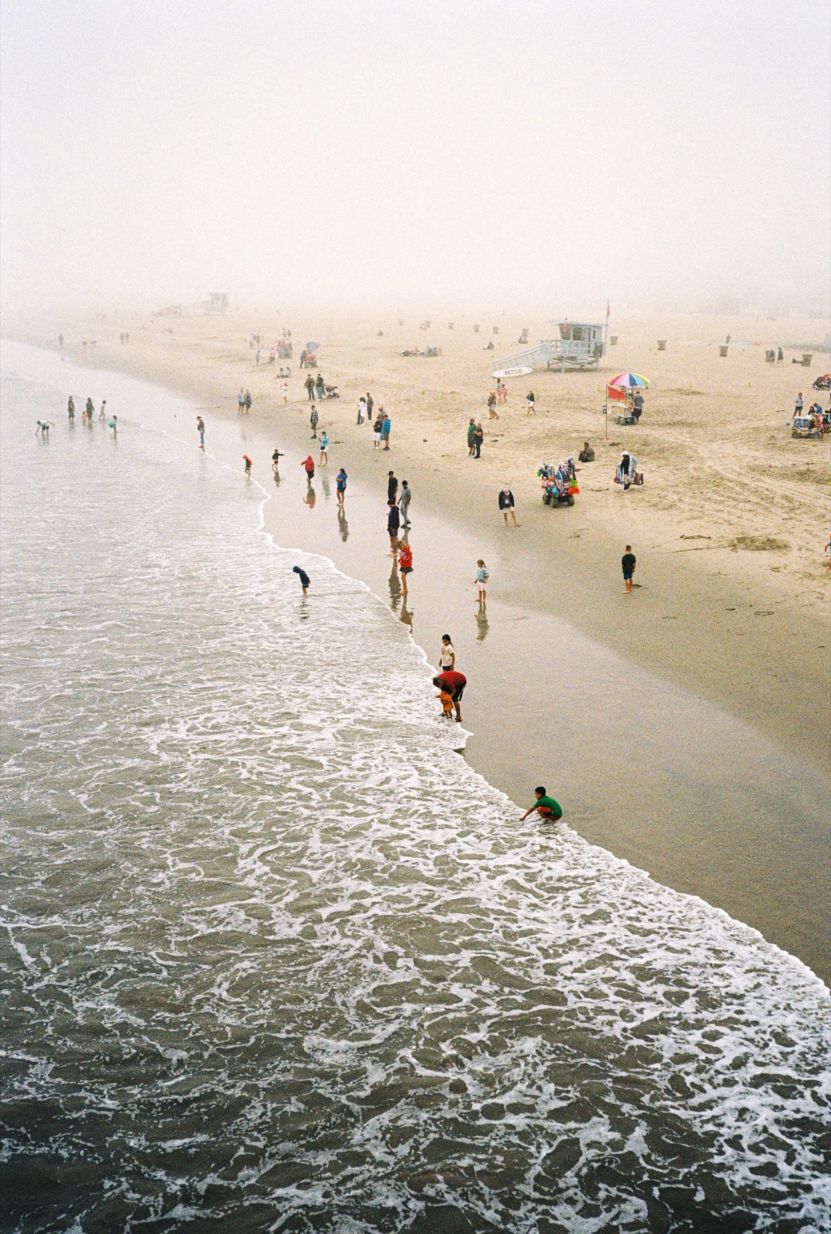 Beachgoers along the Santa Monica shoreline as a marine layer rolls in from the Pacific