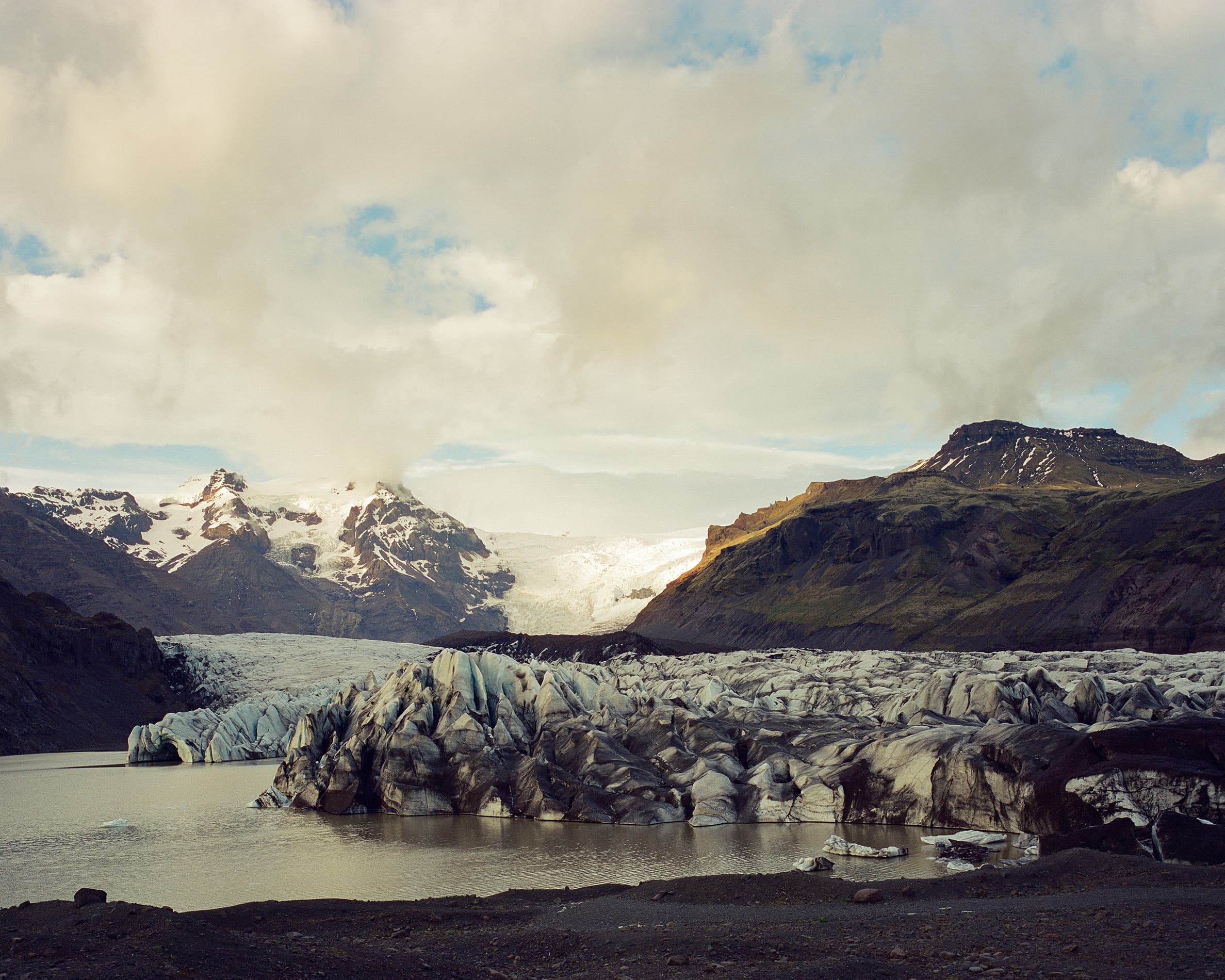 The jagged blue-white tongue of Svínafellsjökull glacier descending between dark volcanic mountains
