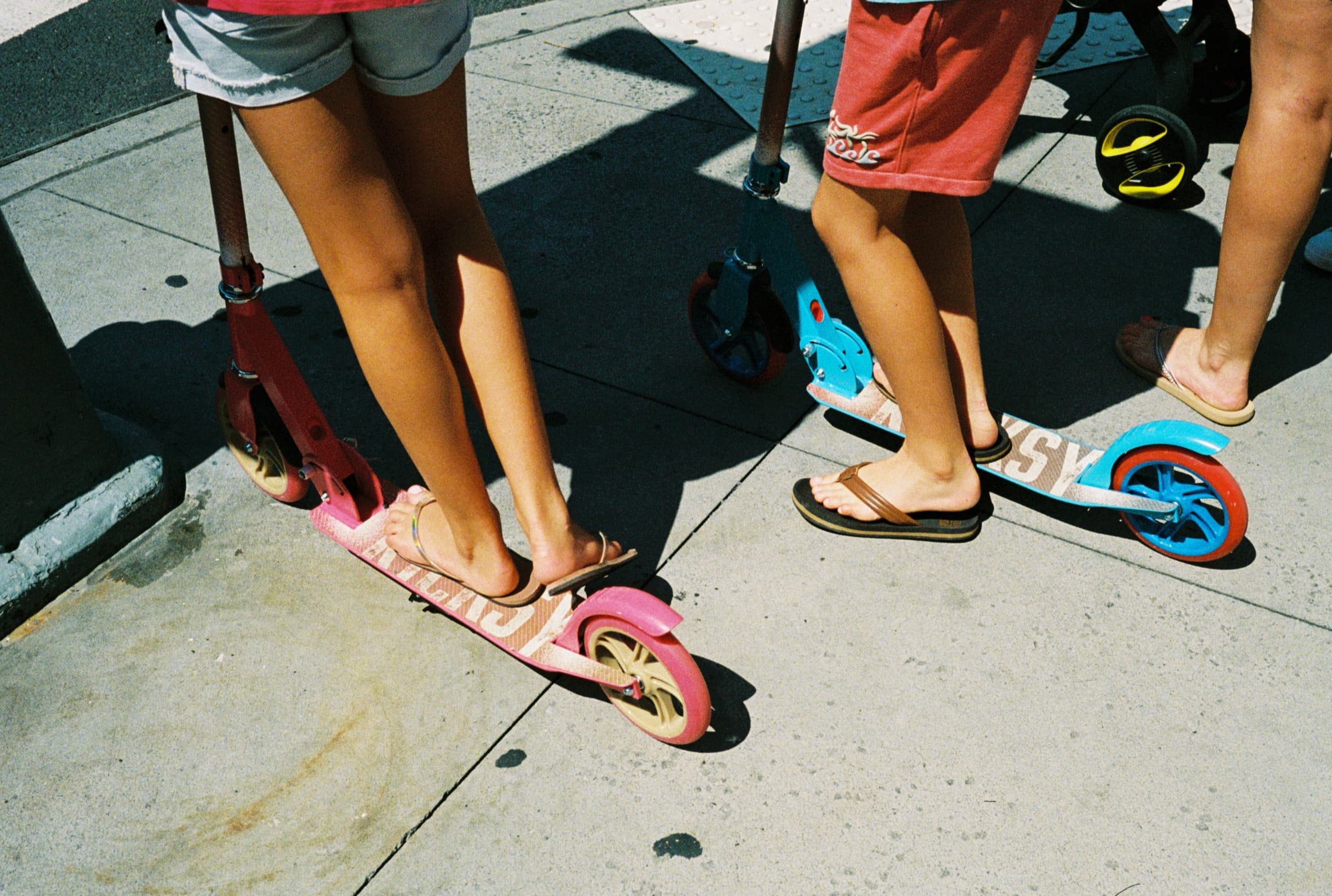 Kids riding scooters on a sunny day in the Upper East Side