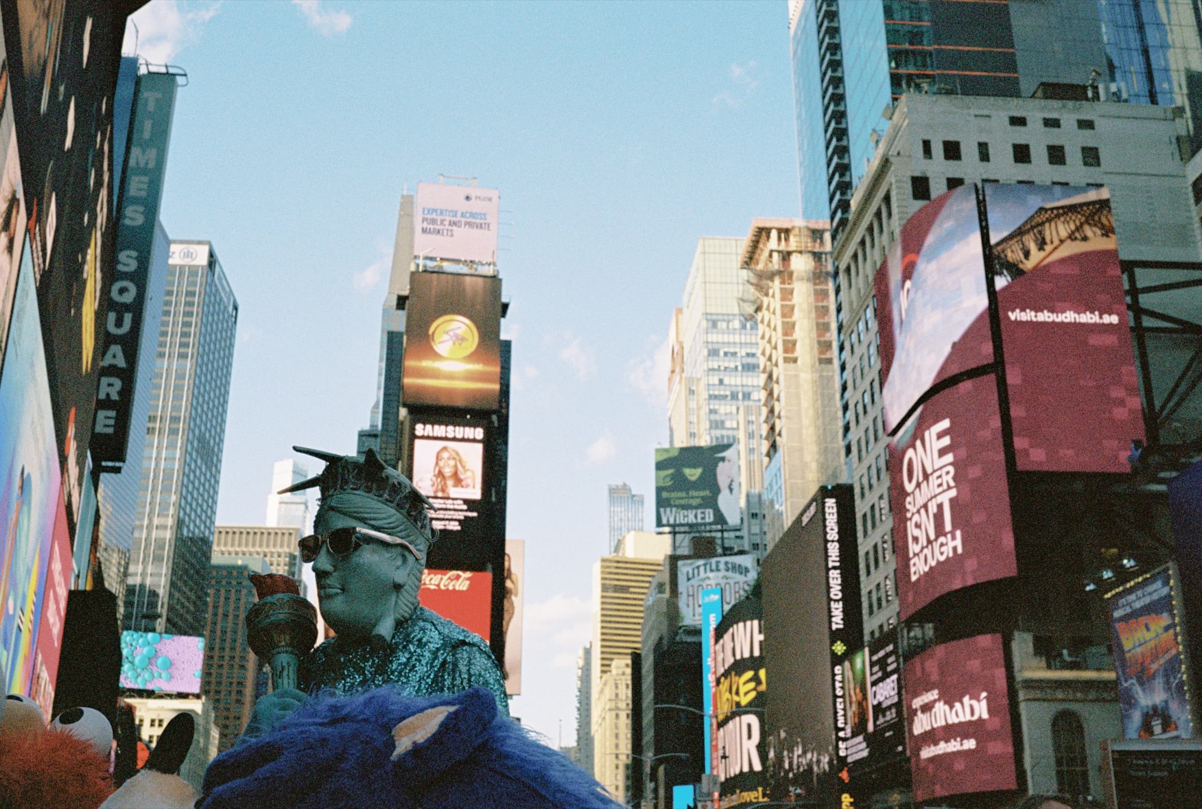 Crowded Time Square Lady Liberty costume character posing for photos with tourists in New York